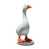 A white resin duck figurine with an orange beak and feet, standing on a gray base.