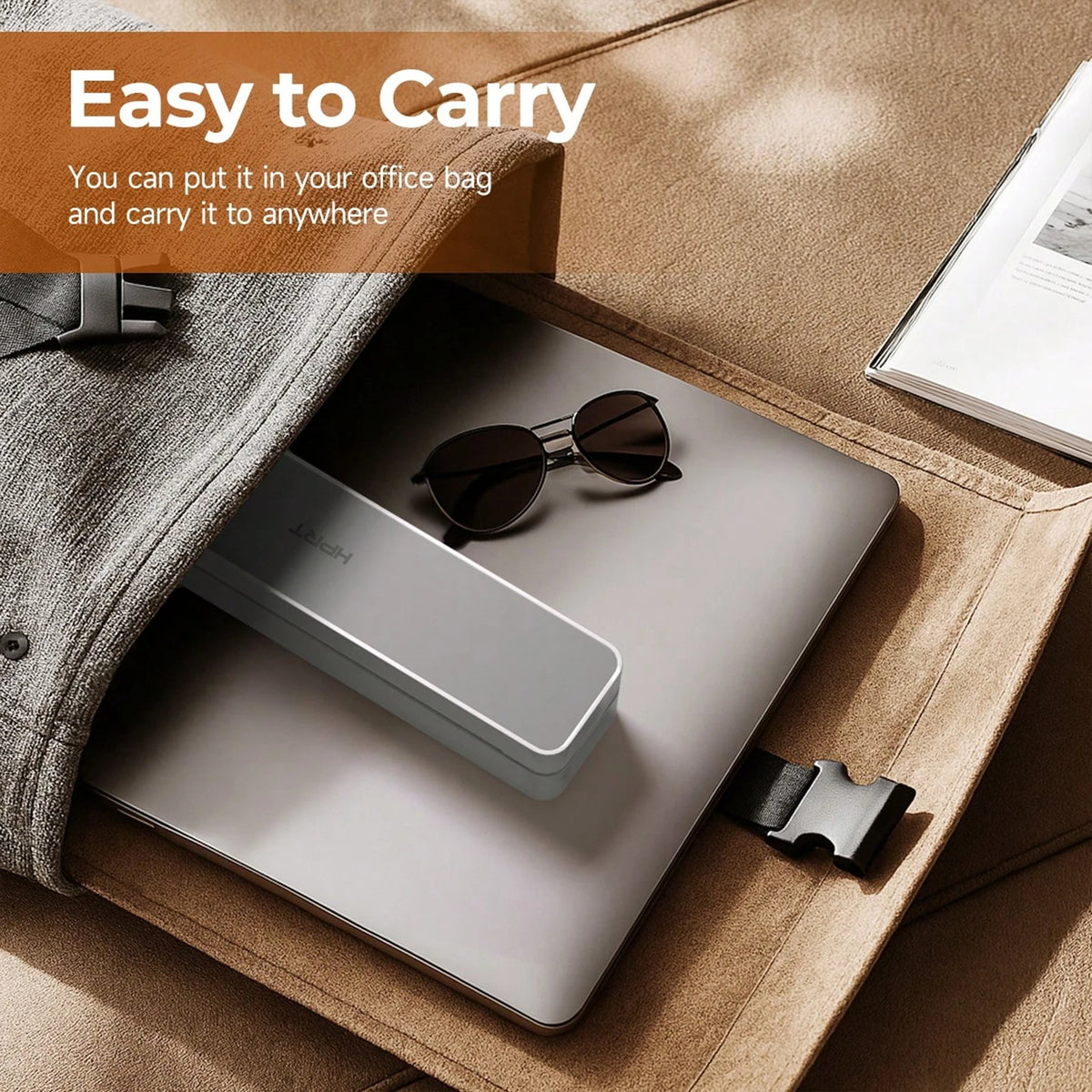 A compact thermal receipt printer is shown resting on a laptop within a brown leather case.