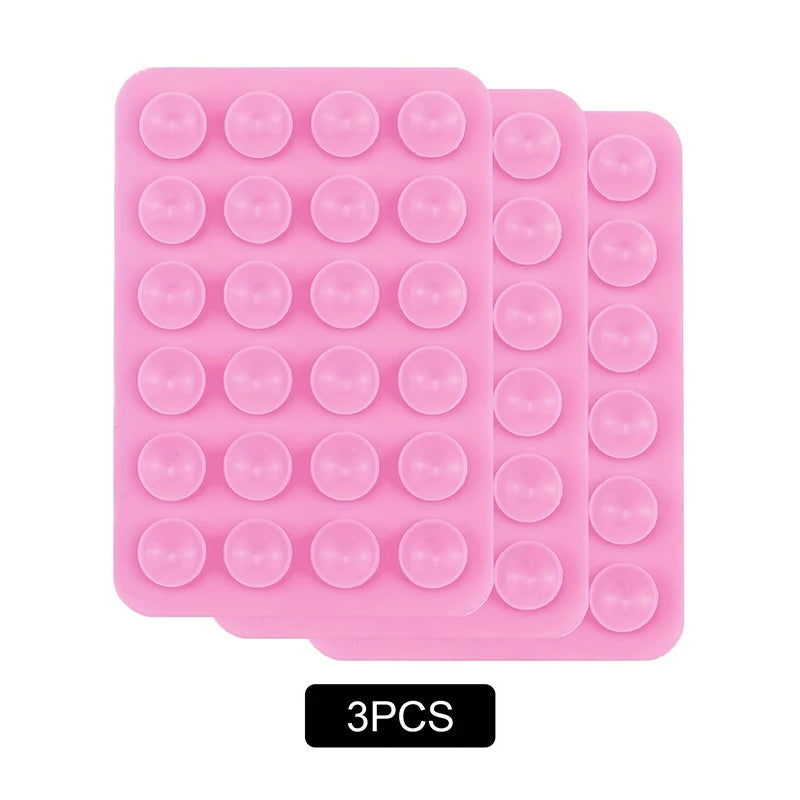 A pack of three pink silicone suction phone mounts with circular suction cups.