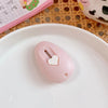 A pink cat paw mini cutter is placed on a white plate next to a notebook and woven mat.
