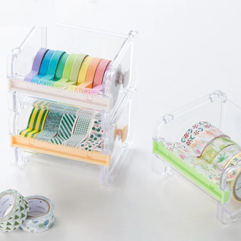 Un dispensador de plástico transparente contiene varias cintas washi de colores, incluyendo tonos pastel y estampadas.