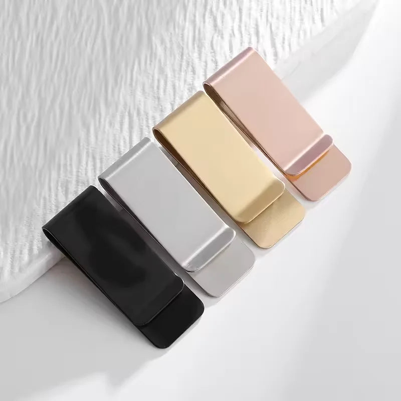A collection of five vintage solid brass money clips in various colors, including gold, rose gold, silver, and black, arrange