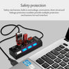 A black 7-port USB hub with individual power switches and blue LED indicators connected to a laptop.