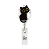 A black cat charm on a silver retractable ID badge holder with a crocodile clip.