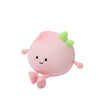 A soft pink, peach-shaped rechargeable night light with green accents and small limbs.