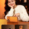 A woman is shown watching TV while using a phone holder to charge her phone.