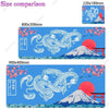A blue desk mat featuring a Japanese dragon and Mount Fuji design with pink cherry blossoms.