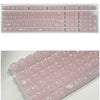 A close-up view of translucent pink ice crystal mechanical keycaps for Cherry MX switches arranged in a tray.