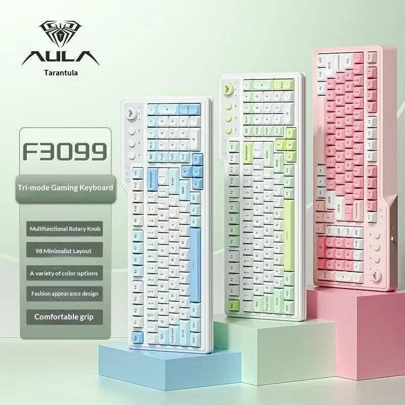Eine weiße Tri-Modus-Gaming-Tastatur neben rosa und grün gefärbten Tastenkappen auf einer hellen Oberfläche.