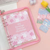 A pink A5 envelope budget binder set with a pink elastic closure and several pink envelopes on a light pink background.