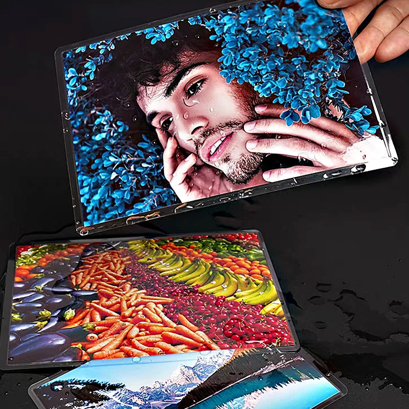 A hand holds a clear thermal laminating pouch containing a vibrant image of a man with blue flowers.