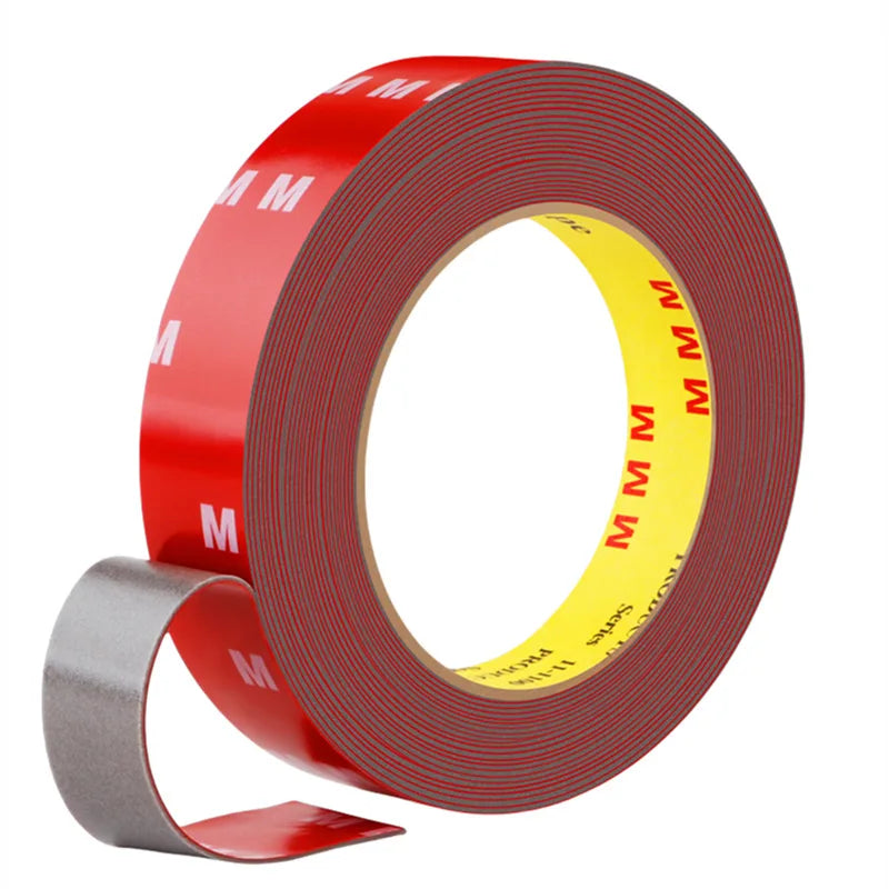 Roll of red heavy duty acrylic foam double sided tape with yellow markings and a gray applicator tool