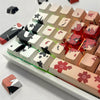 A close-up view of a tray of anime themed PBT keycaps for mechanical keyboards, featuring various characters and designs.