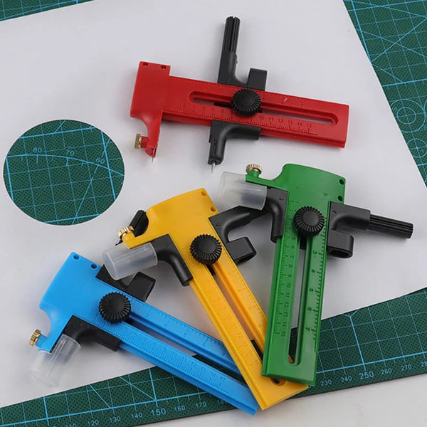 A collection of red, yellow, and green adjustable circle cutting tools for crafting placed on a green grid mat.