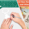 A cutting mat with various craft materials and tools, showing a hand cutting an antler shape.