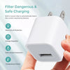 A hand holds a white universal USB wall charger cube with built-in safety features.