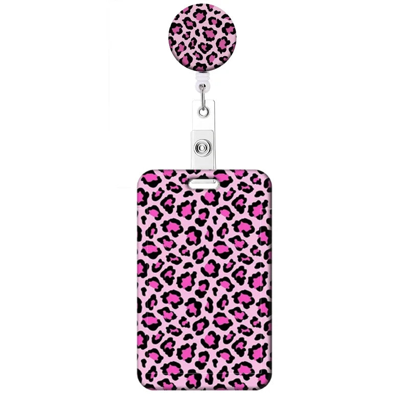 A pink leopard print retractable badge holder with a circular top and a rectangular body.