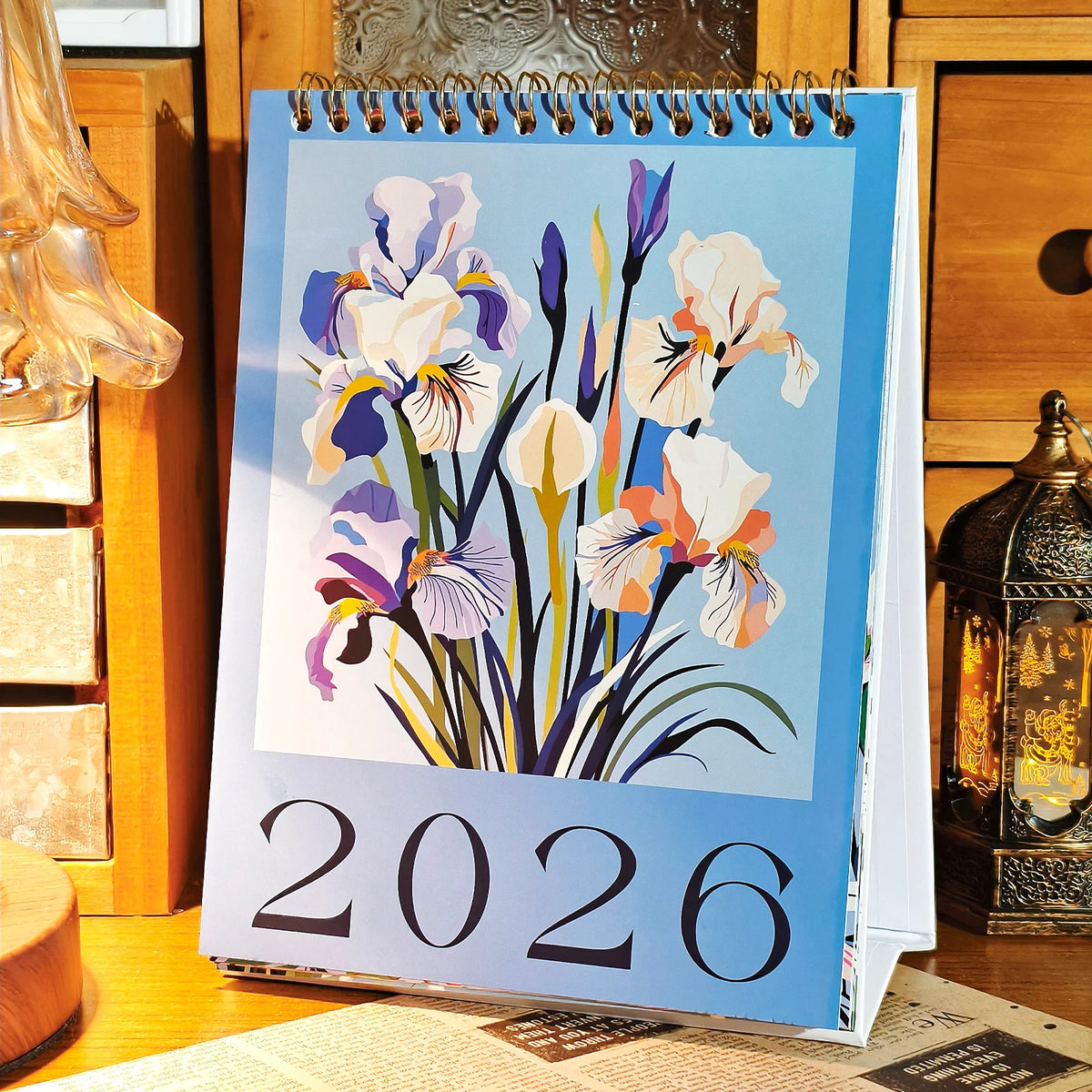 Calendario de escritorio vertical para 2026 con diseños florales acuarelados en morado, blanco y azul.