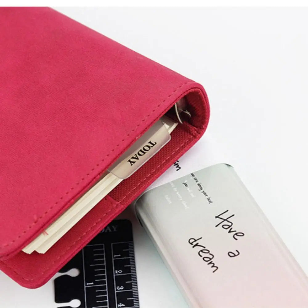 Pinkes Notizbuchcover mit transparentem Buchmarker und klarem Notizbuch sichtbar