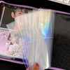 A stack of clear, iridescent photo sleeves for a binder collection displayed on a laptop.