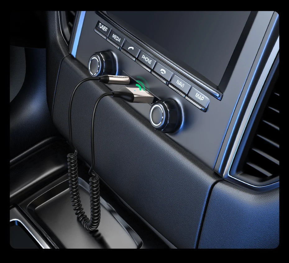 A close-up view of a car stereo unit with various buttons and a connected audio adapter cable.