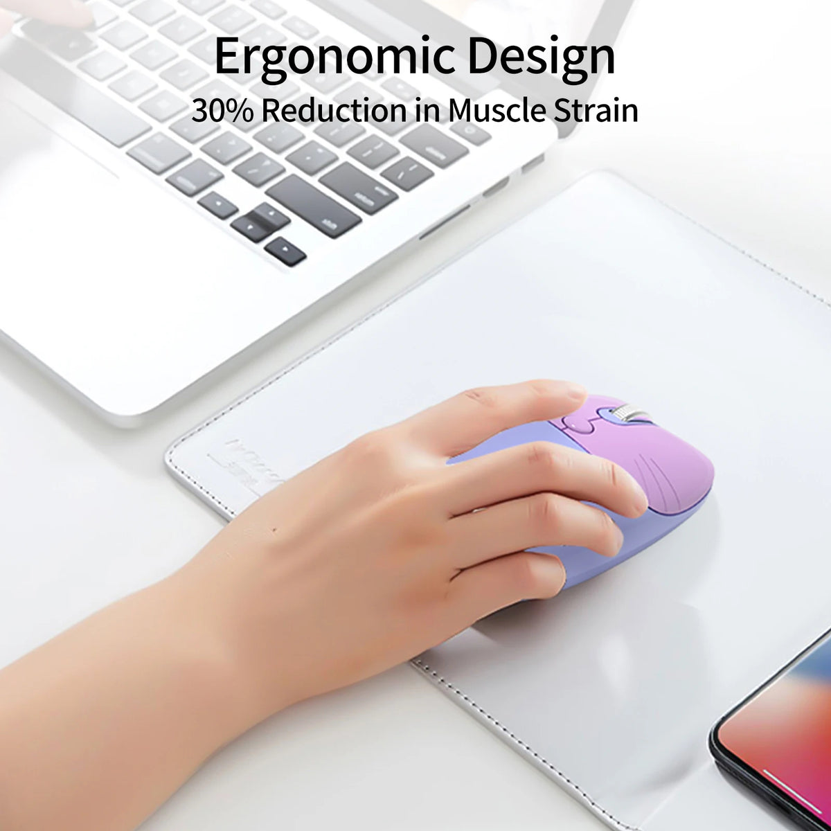 A hand holds a purple gradient cat-shaped wireless mouse on a white tablet beside a laptop.