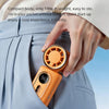 A hand is showing an orange portable handheld cooling fan, which is compact and designed for on-the-go use.