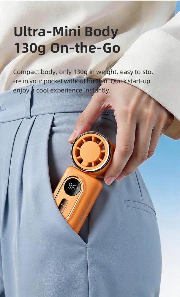 A hand is showing an orange portable handheld cooling fan, which is compact and designed for on-the-go use.
