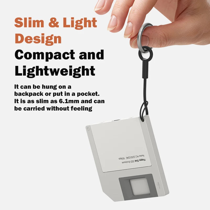 A hand is holding a small, silver M.2 NVMe SSD enclosure for laptop expansion.