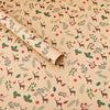 Roll of kraft wrapping paper featuring deer and evergreen designs for Christmas.