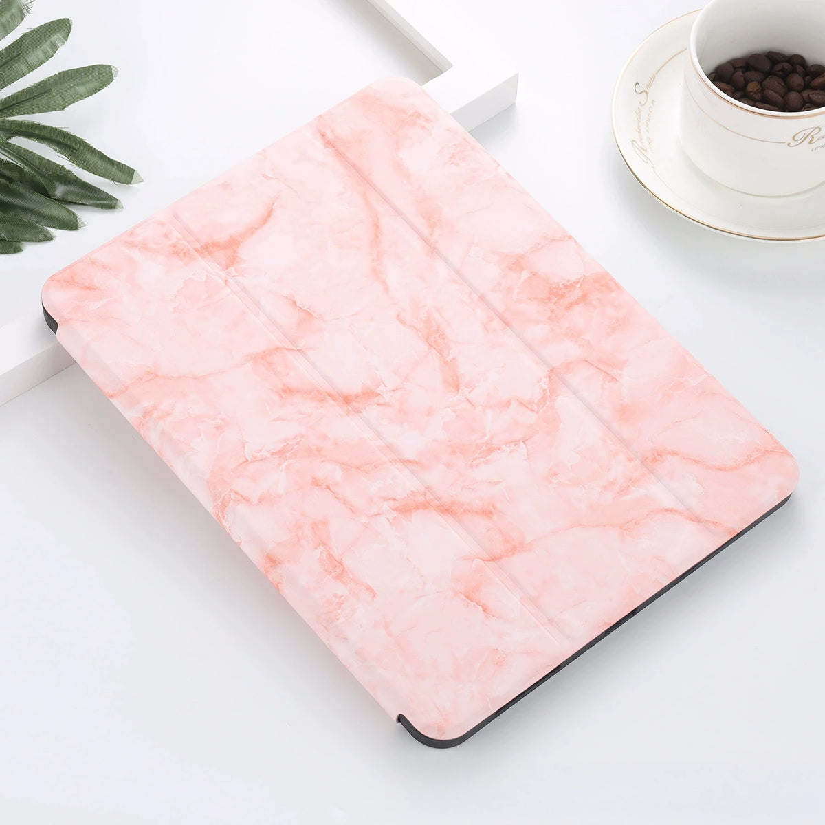 A pink marble-patterned silicone skin for an iPad Pro resting on a white surface.