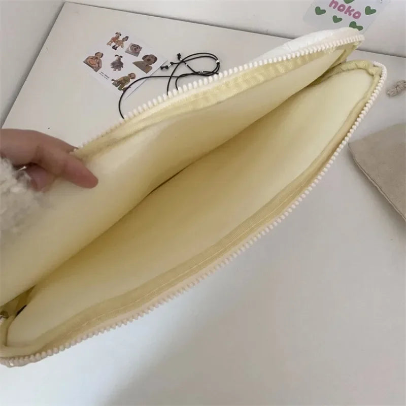 A pale yellow padded laptop sleeve case with a zipper and soft lining is shown diagonally.