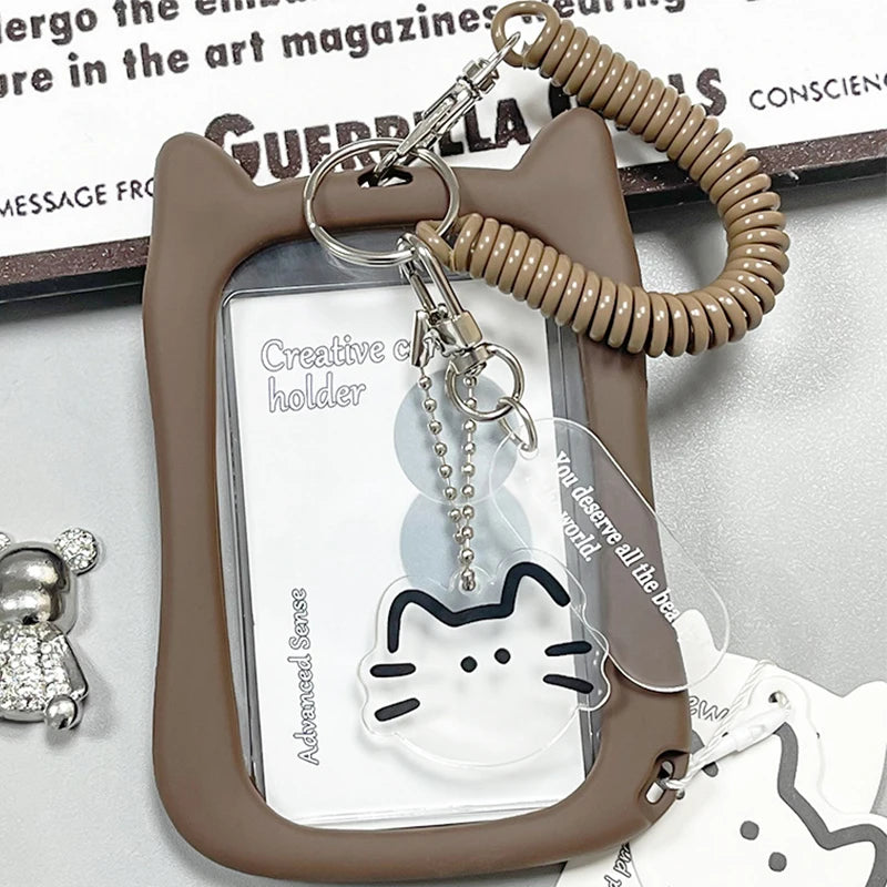 A brown card holder with a clear insert and a beaded keychain attached, featuring a silhouette of a cat.
