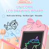 A pink unicorn LCD drawing board showing a colorful unicorn drawing on the screen with a pink pencil nearby.
