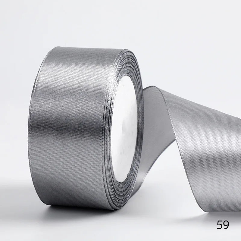 A roll of silver satin ribbon for gift wrapping and DIY crafts.