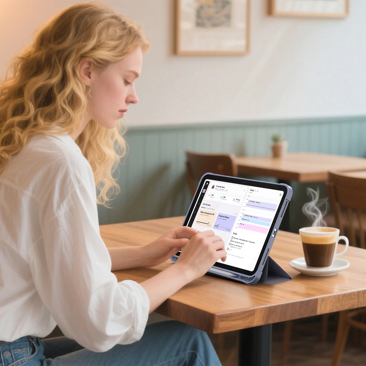 A woman is using a tablet in a cafe setting with a Universal Protective Case for iPad on the table.