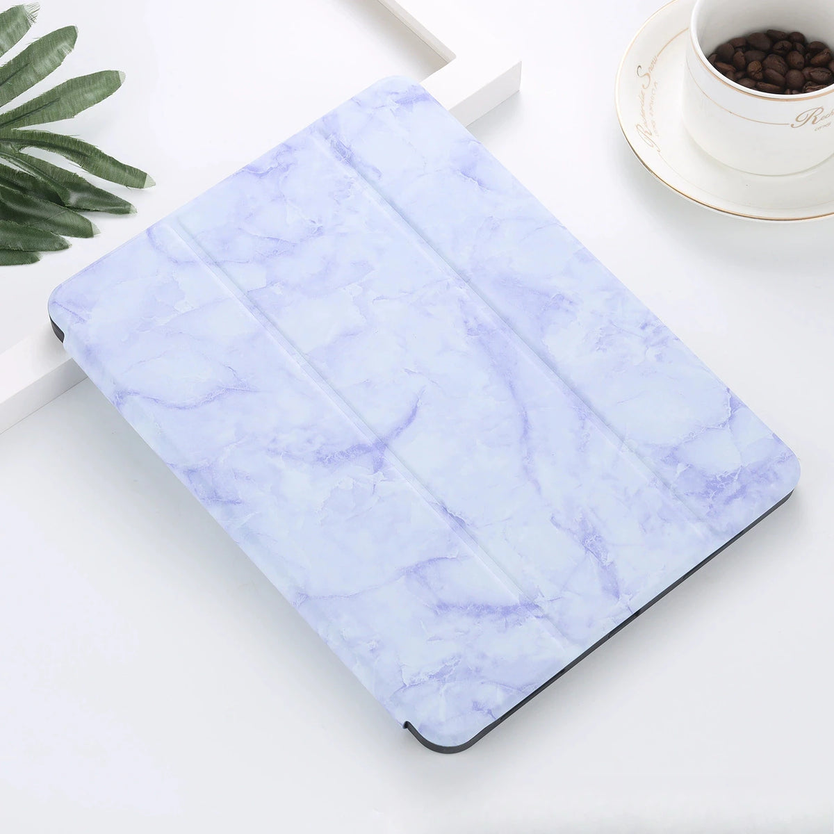 A purple and white marble patterned silicone skin for an iPad Pro placed on a white surface.