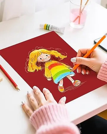 Eine Hand zeichnet ein Kind auf einer roten Karte mit orange-gelben Bricolagefarbstiften.