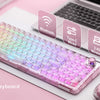 A transparent mechanical keyboard with an RGB backlight and knob is displayed on a white surface next to a laptop.