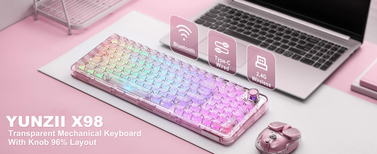 A transparent mechanical keyboard with an RGB backlight and knob is displayed on a white surface next to a laptop.