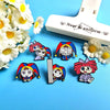 A set of five colorful cartoon anime brooches featuring characters in various poses and outfits on a blue background.
