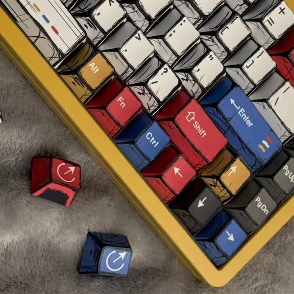A close-up view of a colorful comic style mechanical keycaps set arranged in a yellow tray on a gray surface.