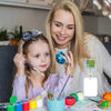 A blonde woman is smiling while a young girl holds a silver badge reel with a glitter acrylic design.