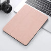 A pink retro marbling skin for an iPad Pro placed next to a silver laptop and a camera.