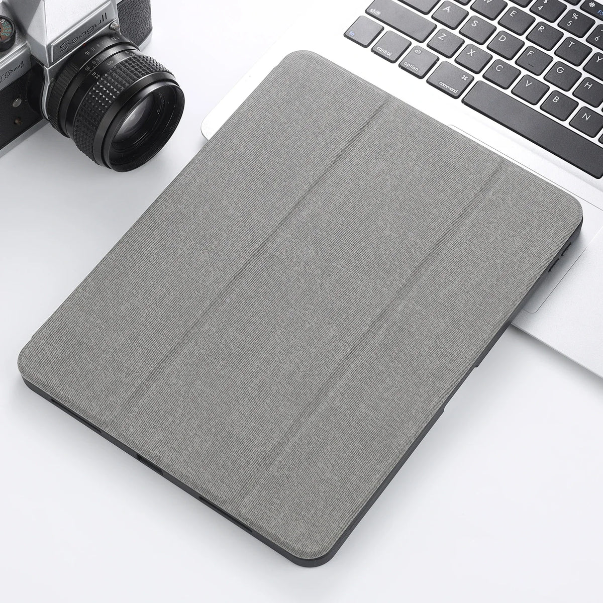 A gray retro marbling skin for an iPad Pro placed next to a laptop and camera lens.