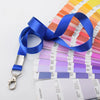 Una pila de muestras de color Pantone y cordones azules exhibidos sobre un fondo blanco.