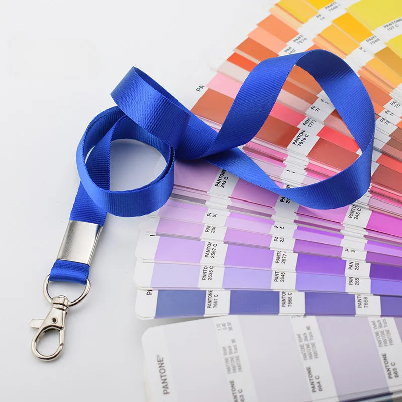 Una pila de muestras de color Pantone y cordones azules exhibidos sobre un fondo blanco.