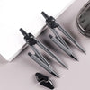 A set of professional drafting tools, including precision pens and a compass, displayed on a white surface.