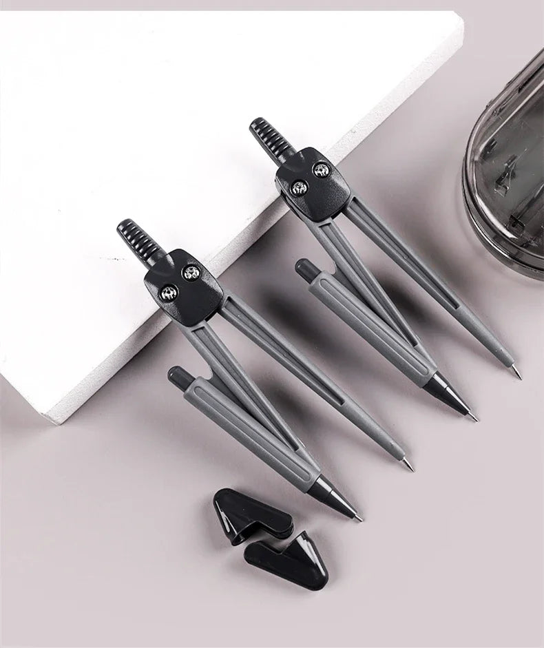 A set of professional drafting tools, including precision pens and a compass, displayed on a white surface.