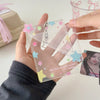 Un pendentif avec un porte-photocard en acrylique transparent décoré d'étoiles colorées et d'un charm argenté.